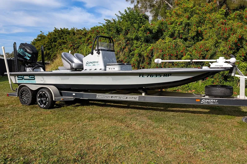 Slide: The Image of 2014 SCB Stingray Sport 25 boat on trailer, parked on grass. - 2