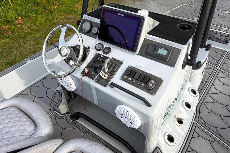 Slide: The Image of 2014 SCB Stingray Sport 25 boat dashboard with steering wheel and electronic controls. - 8