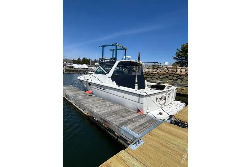 The Image of 2001 Tiara Yachts 3100 Open docked at marina under clear blue sky. - 0