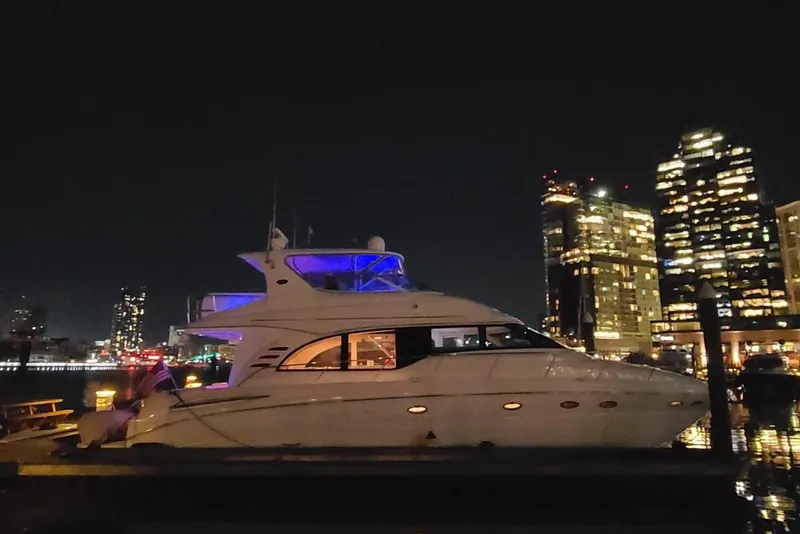Slide: The Image of 2001 Sea Ray 540 Cockpit Motor Yacht docked at night with city skyline. - 2