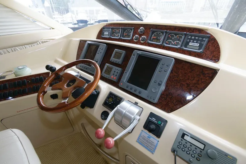 Slide: The Image of 2001 Sea Ray 540 Cockpit Motor Yacht helm with wood accents and navigation instruments. - 24