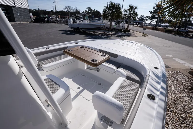 Slide: The Image of 2026 Caymas 28 HB boat interior with seating and table, parked outdoors. - 15