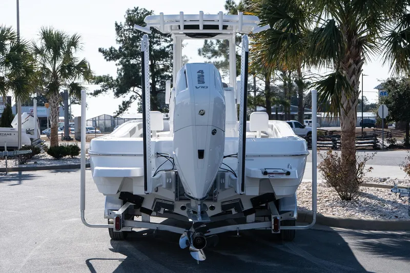 Slide: The Image of 2026 Caymas 28 HB boat with powerful outboard motor, parked near palm trees. - 5