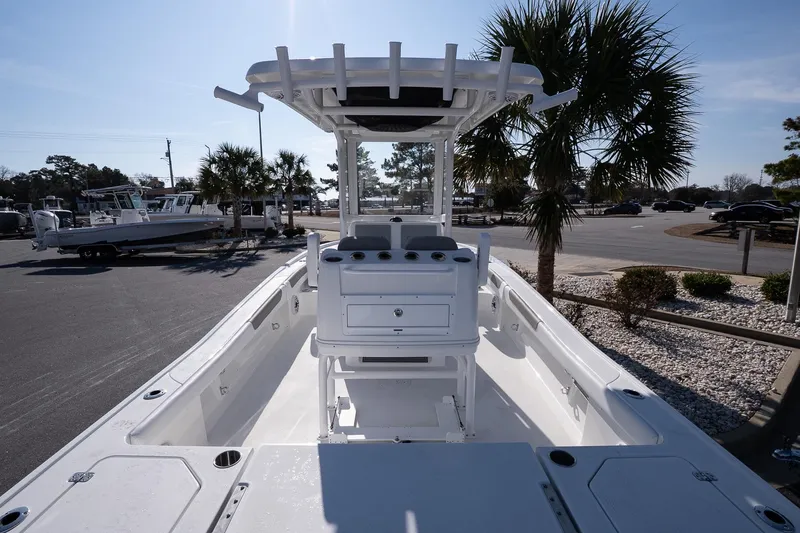 Slide: The Image of 2026 Caymas 28 HB boat with center console, parked near palm trees in a sunny marina. - 8