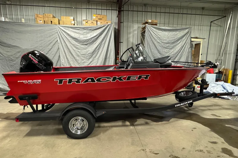 Slide: The Image of 2026 Tracker Pro Guide V-175 WT boat in a garage, red exterior, on a trailer. - 3