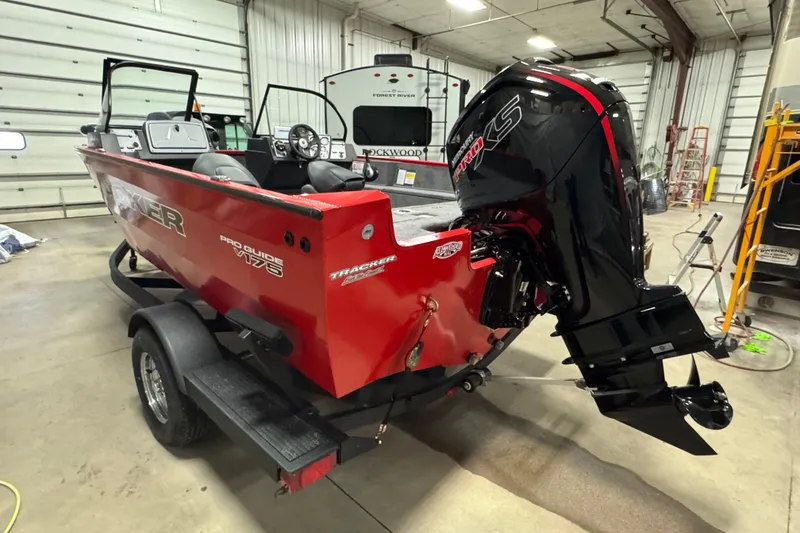 Slide: The Image of 2026 Tracker Pro Guide V-175 WT boat in a garage, featuring a powerful outboard motor. - 5