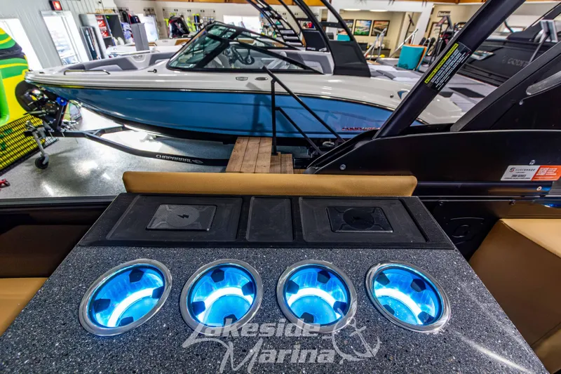 Slide: The Image of Interior of a 2026 Godfrey Monaco 255 MTF with illuminated cup holders and a boat in the background. - 29