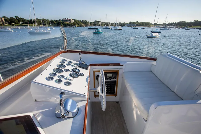 Slide: The Image of Helm of 1964 Huckins Out Islander 56 yacht with scenic harbor view. - 24