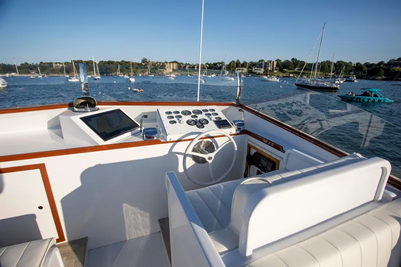 Slide: The Image of 1964 Huckins Out Islander 56 yacht helm with scenic harbor view. - 26