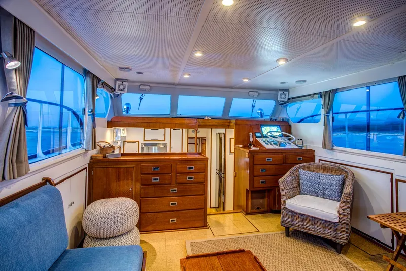 Slide: The Image of Interior of 1964 Huckins Out Islander 56 yacht with cozy seating and wooden cabinetry. - 34