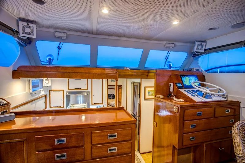Slide: The Image of 1964 Huckins Out Islander 56 yacht interior with wooden cabinetry and helm station. - 35