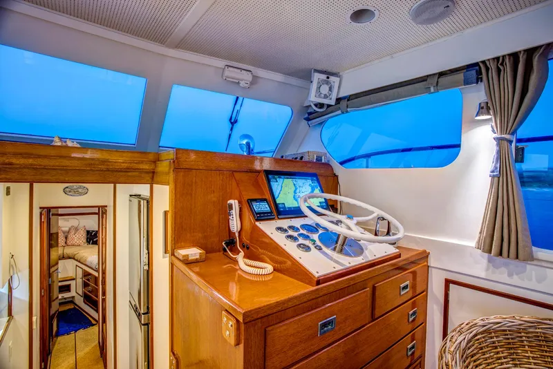 Slide: The Image of 1964 Huckins Out Islander 56 yacht interior with wooden helm and navigation equipment. - 36
