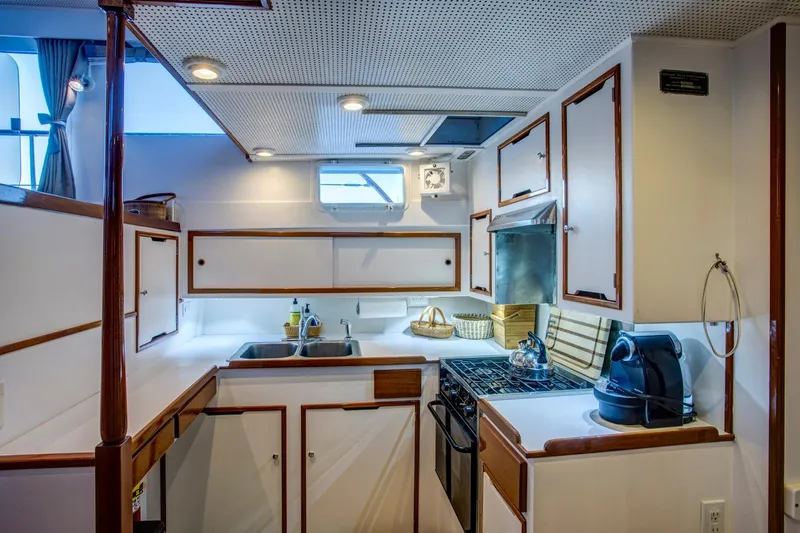 Slide: The Image of 1964 Huckins Out Islander 56 yacht kitchen with modern appliances and wooden cabinetry. - 37