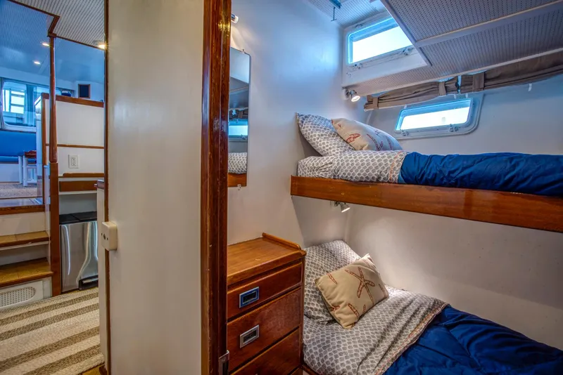 Slide: The Image of Interior of 1964 Huckins Out Islander 56 yacht with cozy bunk beds and wooden cabinetry. - 41