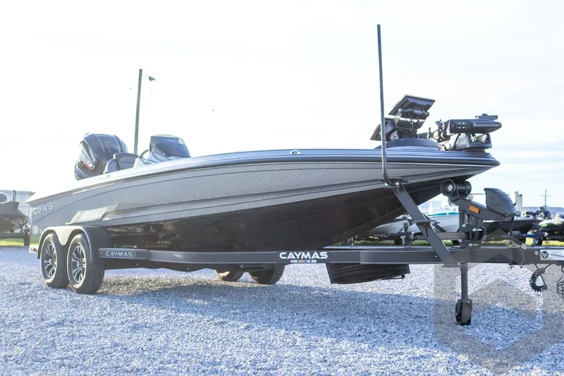 Slide: The Image of 2026 Caymas CX 21 PRO boat on trailer, sleek design, parked on gravel. - 11