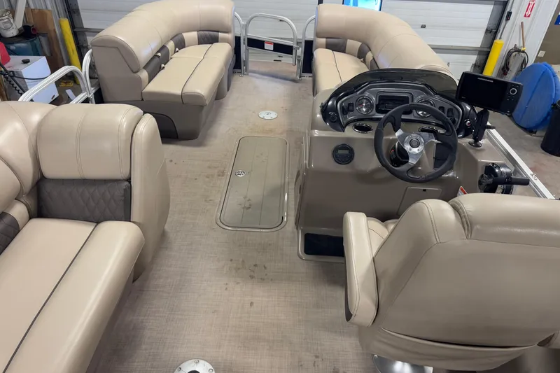 Slide: The Image of 2020 Sun Tracker SportFish 22 XP3 pontoon boat interior with beige seating and steering console. - 18