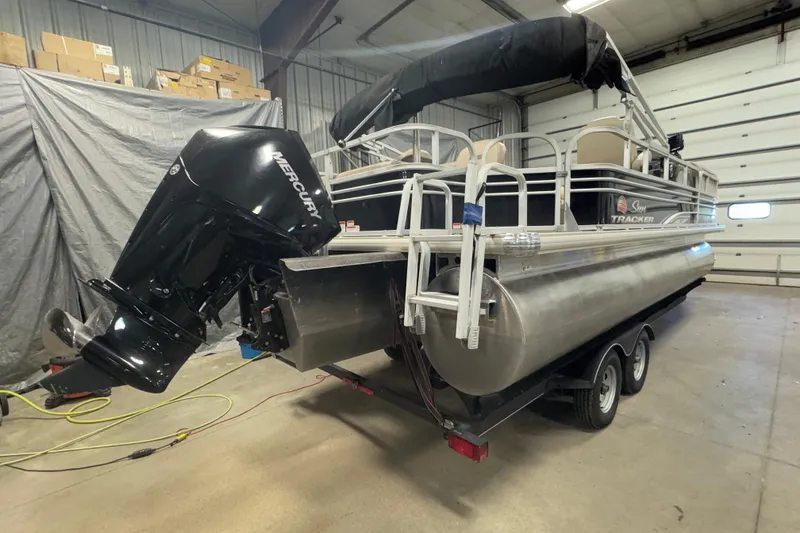 Slide: The Image of 2020 Sun Tracker SportFish 22 XP3 pontoon boat with Mercury outboard motor in a garage. - 4