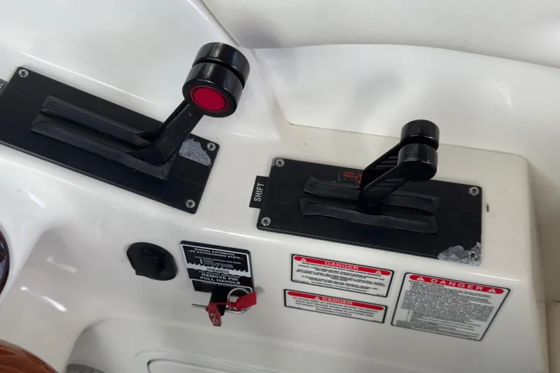 Slide: The Image of 2003 Sea Ray 290 Bowrider throttle controls with safety warnings and ignition key. - 10