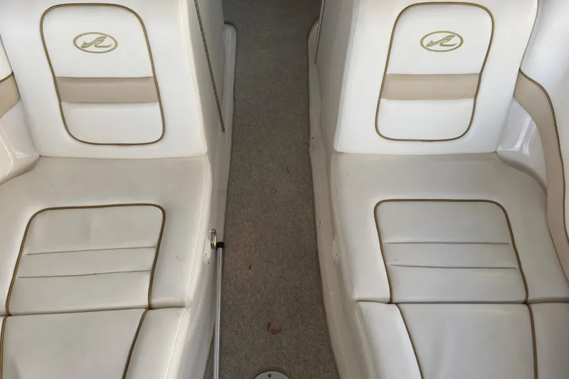 Slide: The Image of 2003 Sea Ray 290 Bowrider interior seating with white and beige upholstery. - 16