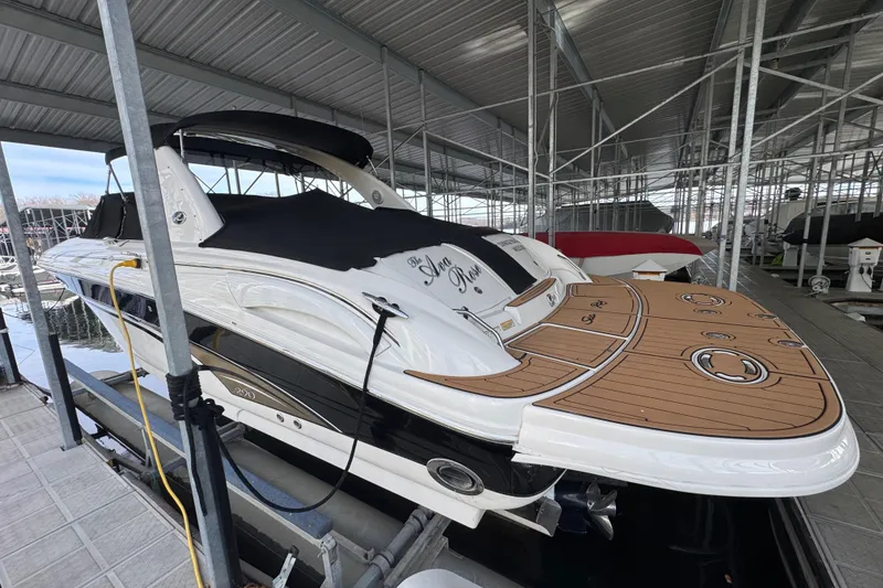 Slide: The Image of 2003 Sea Ray 290 Bowrider docked under a metal canopy. - 2
