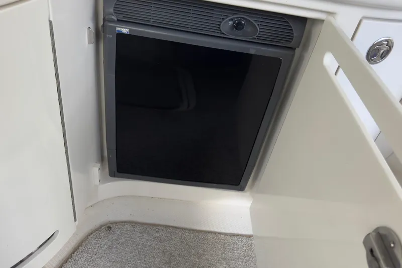 Slide: The Image of 2003 Sea Ray 290 Bowrider interior with built-in mini fridge. - 29