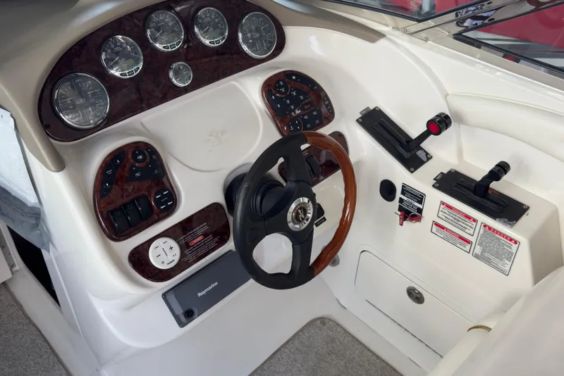 Slide: The Image of 2003 Sea Ray 290 Bowrider dashboard with steering wheel and control panel. - 9