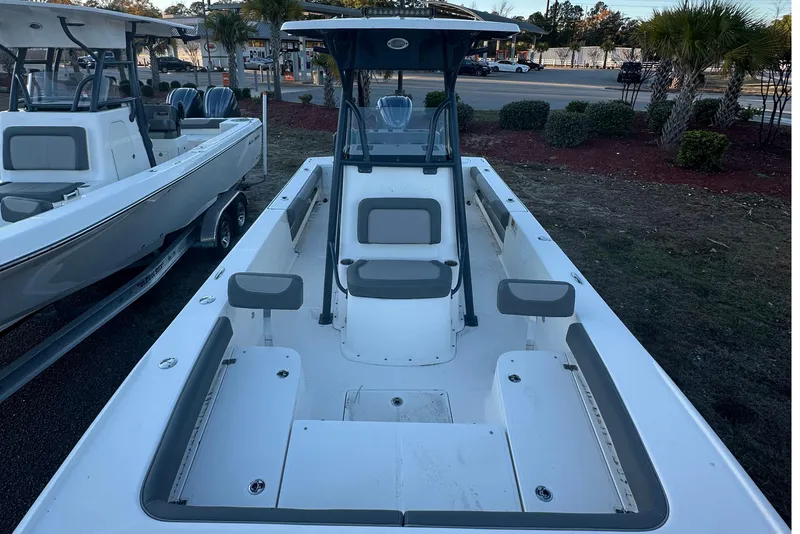 Slide: The Image of 2024 Sea Born FX 25 LE boat, white interior, parked outdoors with palm trees nearby. - 3