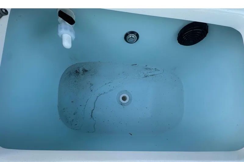 Slide: The Image of 2024 Sea Born FX 25 LE boat livewell interior with drain and debris. - 4