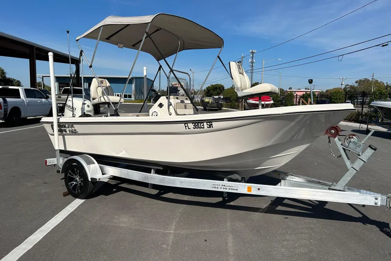 The Image of 2020 Carolina Skiff 162 JLS boat on trailer with canopy in parking lot. - 1