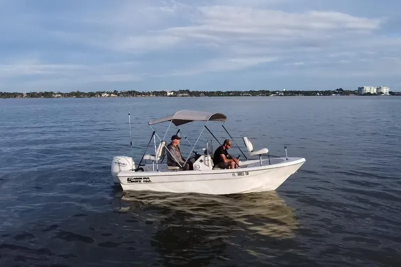 Slide: The Image of 2020 Carolina Skiff 162 JLS boat on calm water with two people onboard. - 17