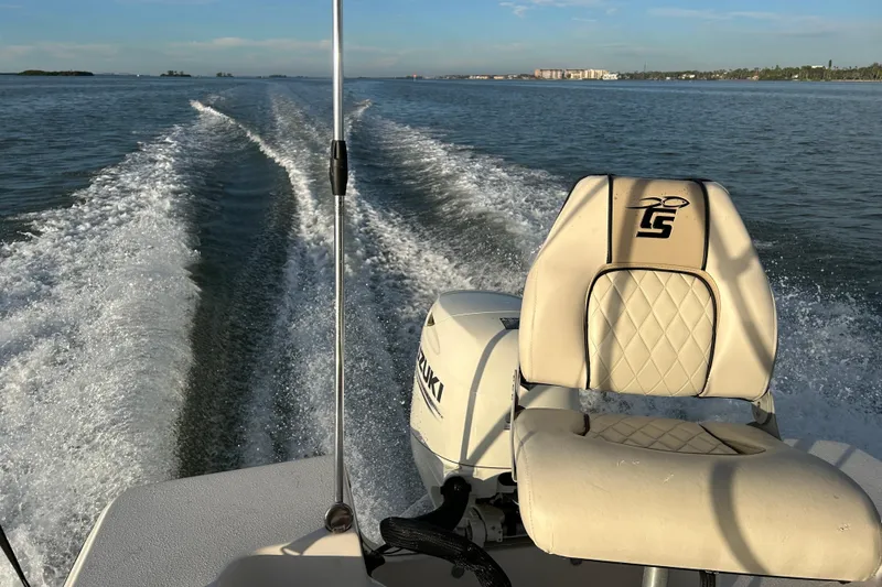 Slide: The Image of 2020 Carolina Skiff 162 JLS boat cruising on open water, leaving a wake trail. - 19