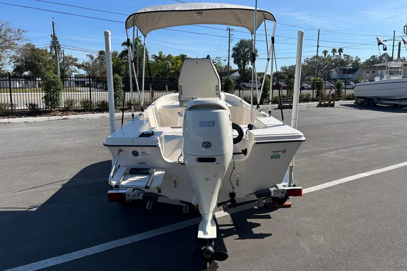 Slide: The Image of 2020 Carolina Skiff 162 JLS boat with outboard motor and canopy in parking lot. - 3