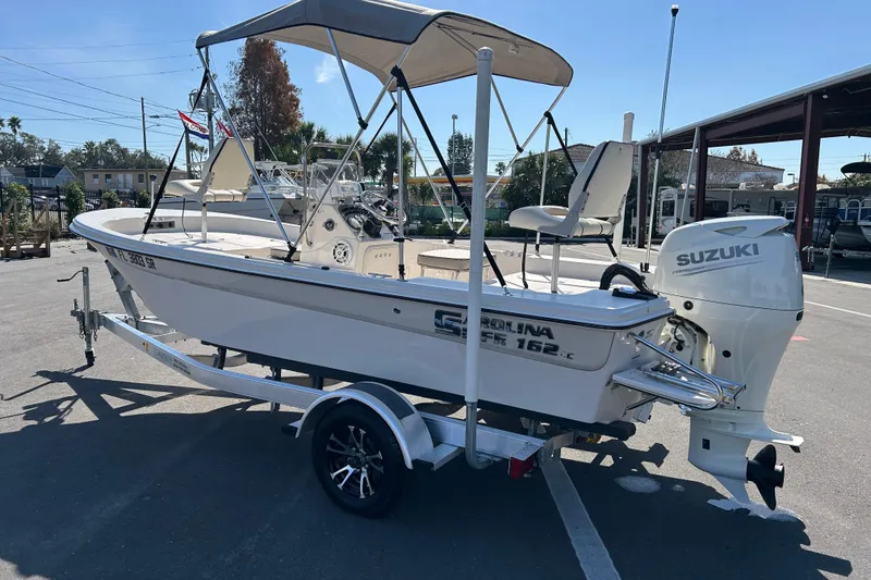 Slide: The Image of 2020 Carolina Skiff 162 JLS boat with Suzuki outboard motor on trailer. - 4