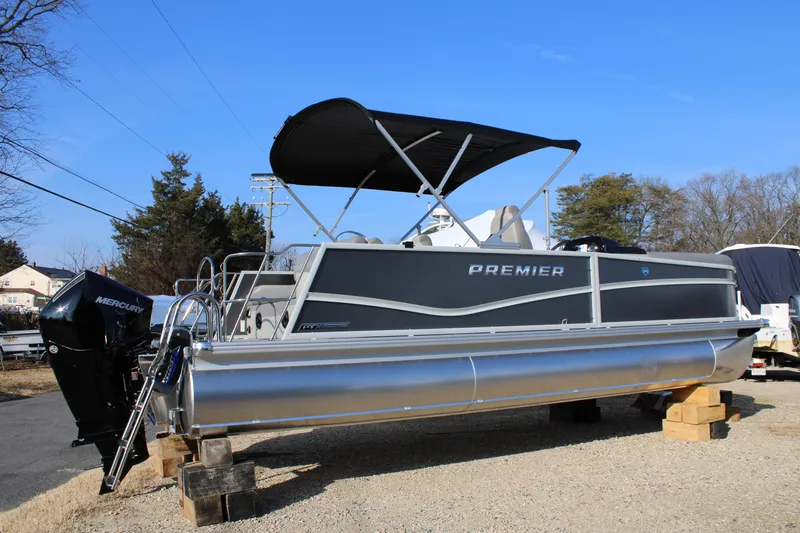 Slide: The Image of 2026 Premier 230 Sunsation RF CL pontoon boat with Mercury engine, parked on blocks. - 1