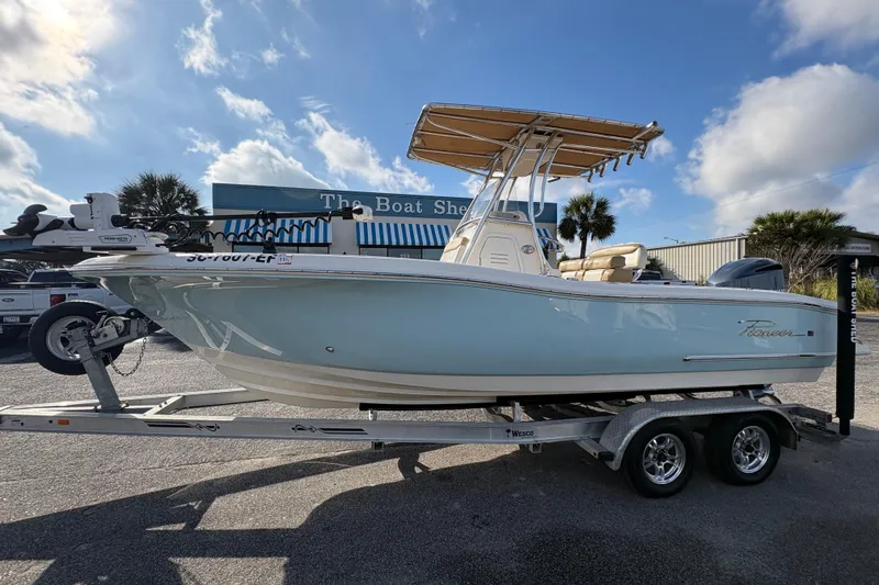 The Image of 2020 Pioneer 222 Sportfish boat on trailer at dealership under blue sky. - 1