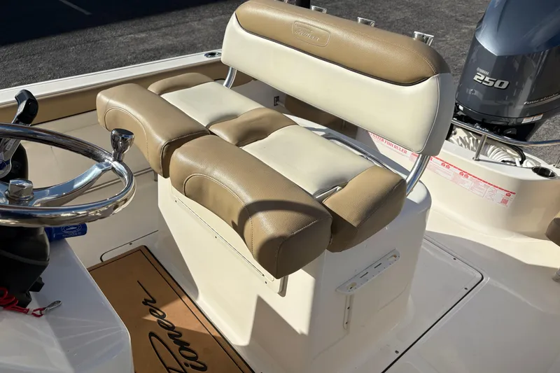 Slide: The Image of 2020 Pioneer 222 Sportfish boat interior with steering wheel and cushioned seating. - 13