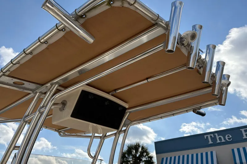 Slide: The Image of 2020 Pioneer 222 Sportfish boat T-top with rod holders against blue sky. - 14