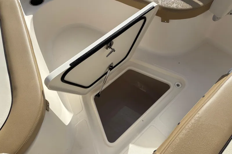 Slide: The Image of Open storage compartment on 2020 Pioneer 222 Sportfish boat, featuring beige seating. - 26