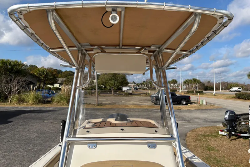 Slide: The Image of 2020 Pioneer 222 Sportfish boat with T-top, parked outdoors under a cloudy sky. - 28
