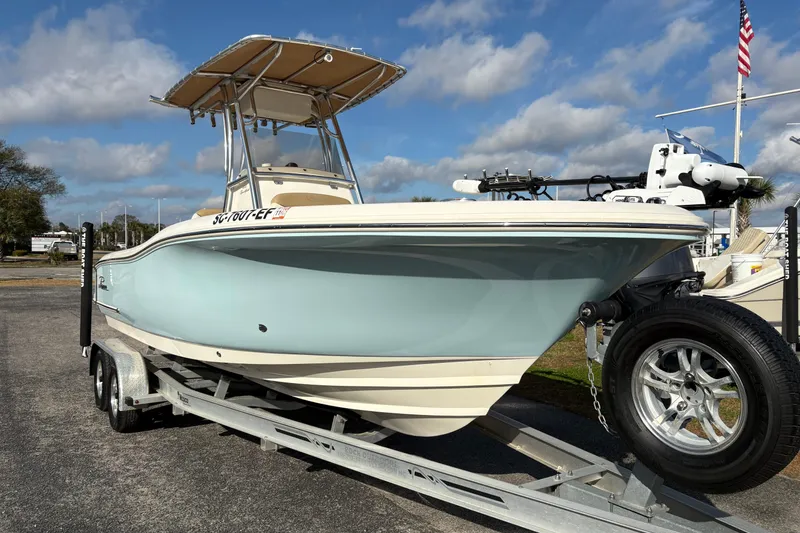 Slide: The Image of 2020 Pioneer 222 Sportfish boat on trailer, light blue hull, sunny day, American flag in background. - 6