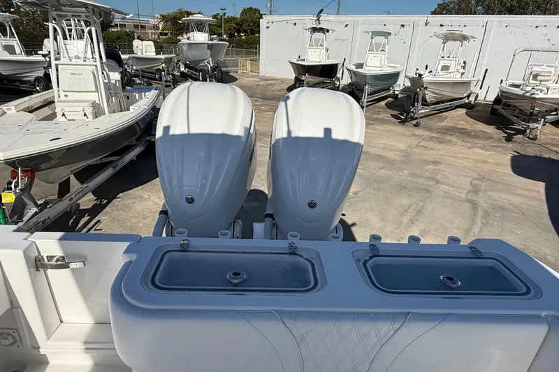 Slide: The Image of 2024 Contender 30 ST boat with dual engines, docked among other boats. - 13