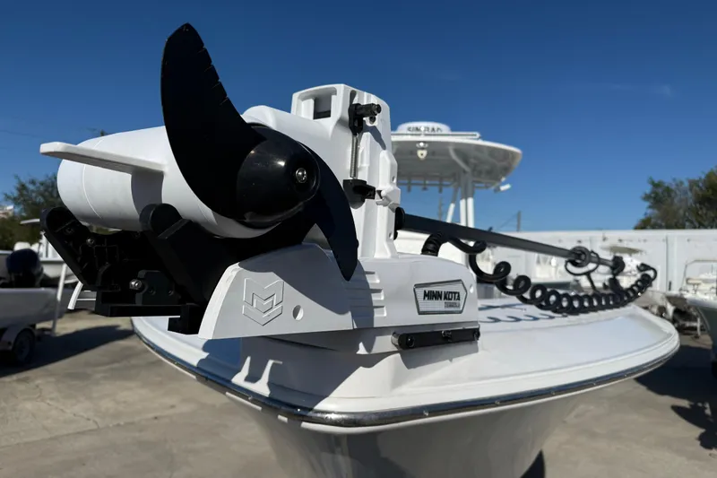 Slide: The Image of 2024 Contender 30 ST boat with Minn Kota trolling motor, docked under clear blue sky. - 15