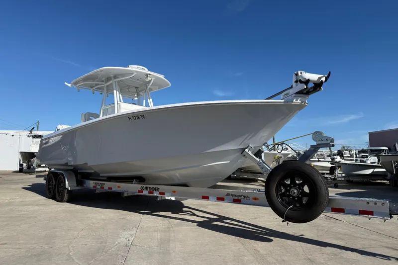 Slide: The Image of 2024 Contender 30 ST boat on trailer under clear blue sky. - 19