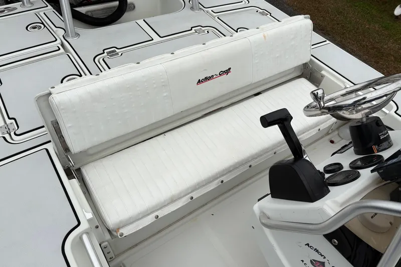 Slide: The Image of 2017 Action Craft Flatsmaster 1820 boat interior with white seating and steering console. - 13