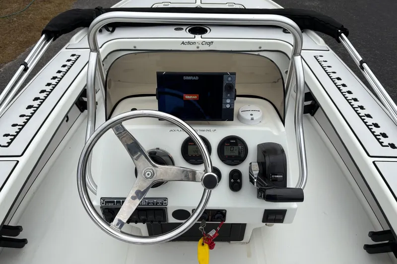 Slide: The Image of 2017 Action Craft Flatsmaster 1820 boat dashboard with steering wheel and navigation system. - 14
