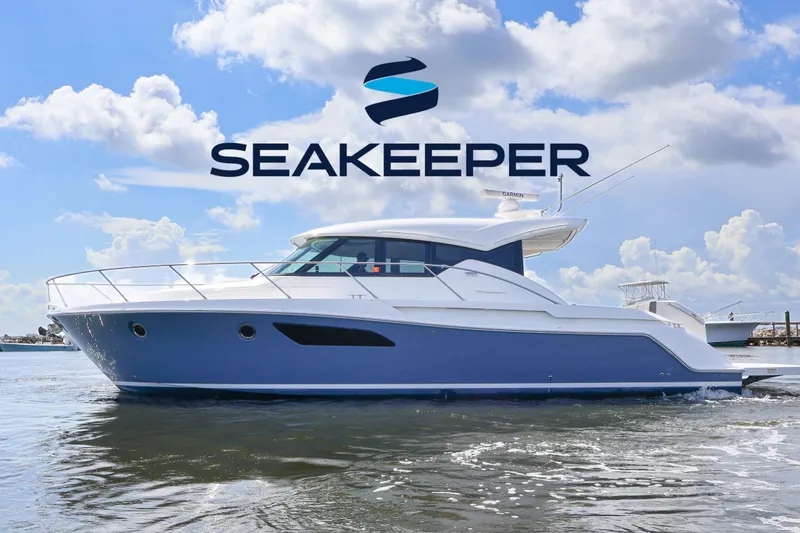 Slide: The Image of 2020 Tiara Yachts C44 Coupe on water under Seakeeper logo, clear sky background. - 1