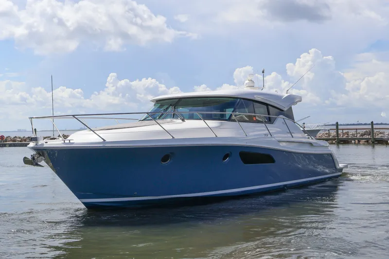 Slide: The Image of 2020 Tiara Yachts C44 Coupe cruising on calm waters under a cloudy sky. - 4