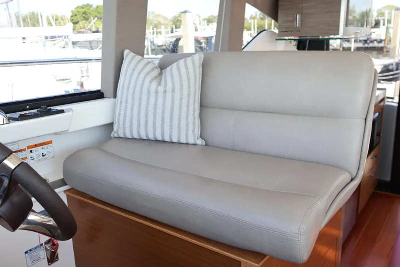 Slide: The Image of 2020 Tiara Yachts C44 Coupe interior with gray leather seating and striped pillow. - 59