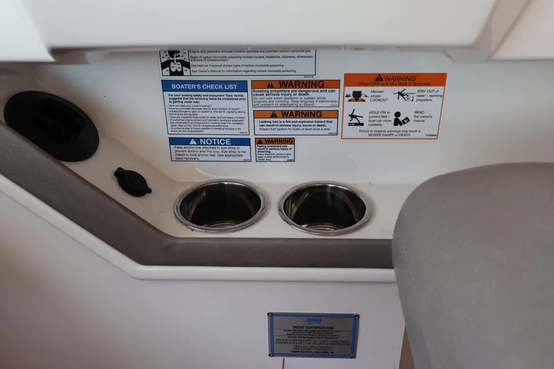 Slide: The Image of Interior of 2020 Tiara Yachts C44 Coupe with safety warnings and cup holders. - 65