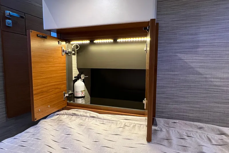 Slide: The Image of Open cabinet with fire extinguisher inside Tiara Yachts C44 Coupe, 2020 model. - 92